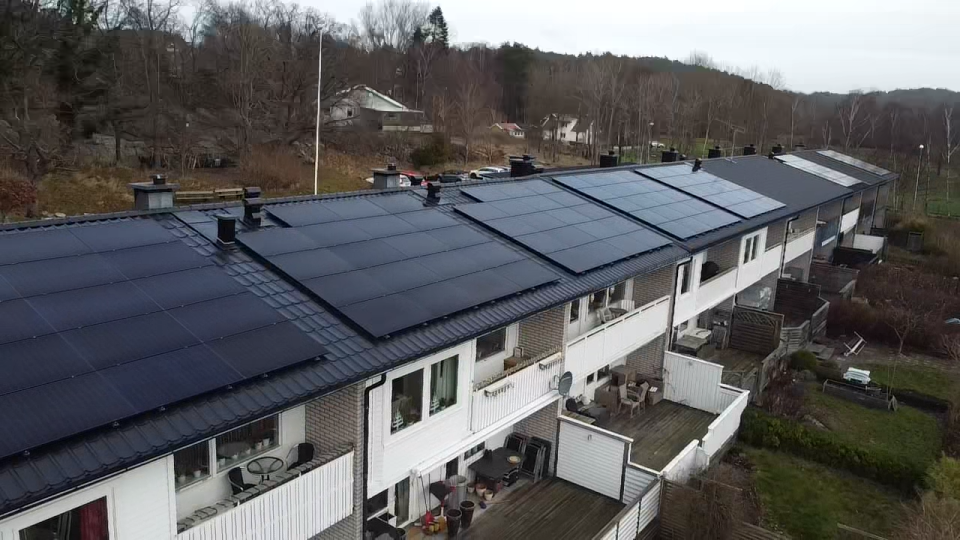 Bild av åtta radhus med solceller installerade på taket av varje hus av Solifokus. Solcellerna möjliggör hållbar energiproduktion och minskad miljöpåverkan för varje radhus.